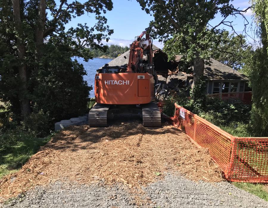 Heavy machinery working beside orange tree protection fencing